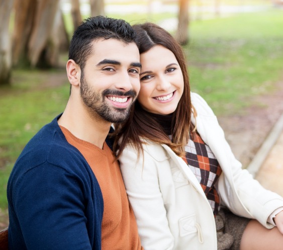 Man and woman sharing healthy smiles after preventive dentistry
