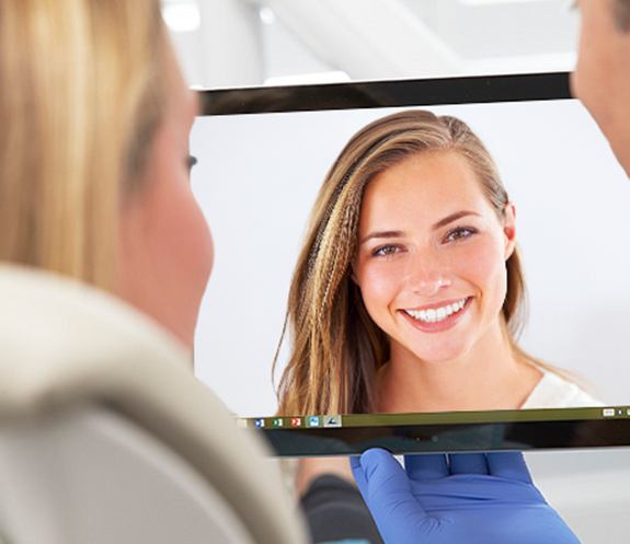 Woman looking at smile makeover plan on computer screen