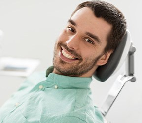Patient smiling while sitting in treatment chair