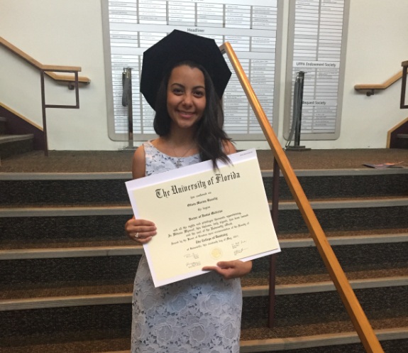 Doctor Bassily holding her degree from the University of Florida