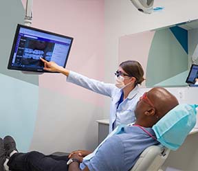 Dentist and patient looking at digital x-rays