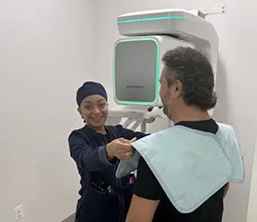Dental team member capturing patient's 3 D C T cone beam x-ray scans