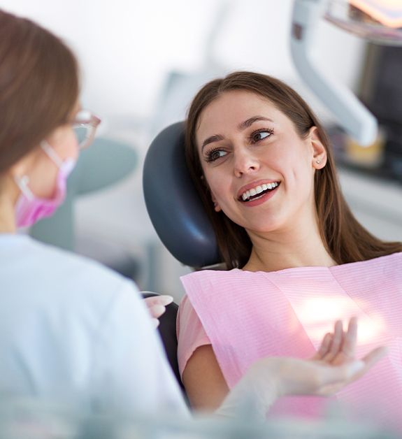 Woman smiling at dentist during dental checkup and teeth cleaning visit