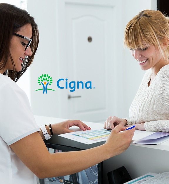 Team member and patient reviewing Cigna dental insurance forms