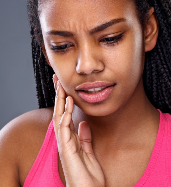 Woman in need of emergency dentistry holding jaw in pain