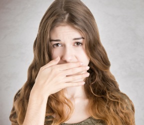 Patient with lost dental crown covering her mouth