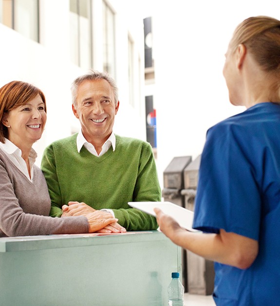 Dental team member discussing dental federal enrollment with patients