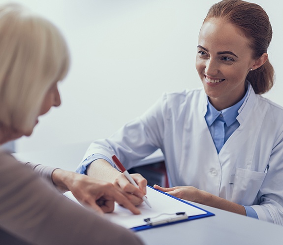 Dentist and dental patient discussing the cost of dental implants