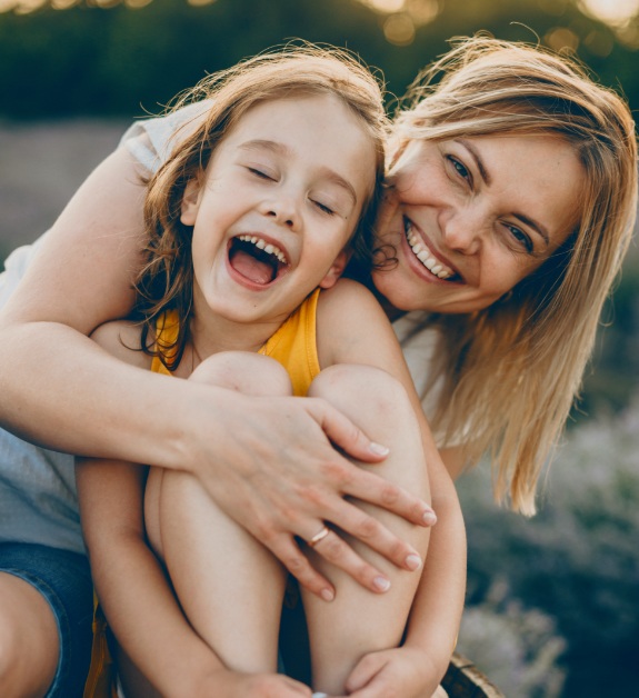 Mother and daughter sharing healthy smiles after visiting their dentist