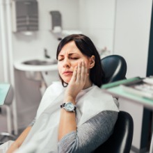 Woman in need of emergency dentistry holding jaw in pain