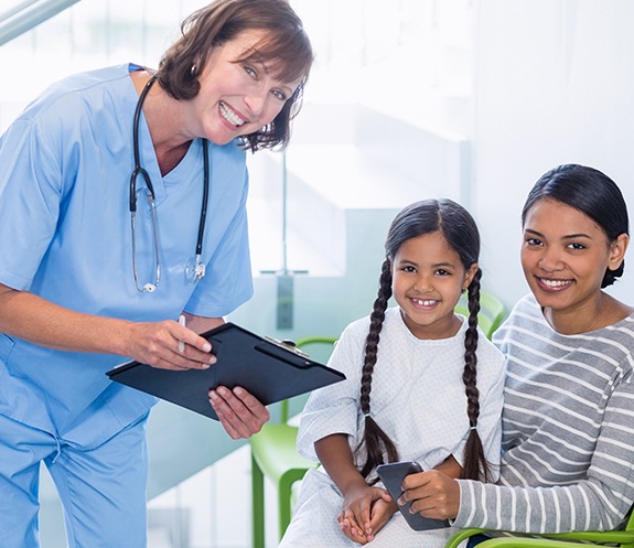 Dentist and dental patient reviewing dental insurance forms