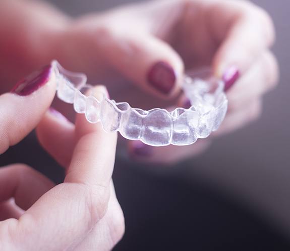 Hand holding an Invisalign tray