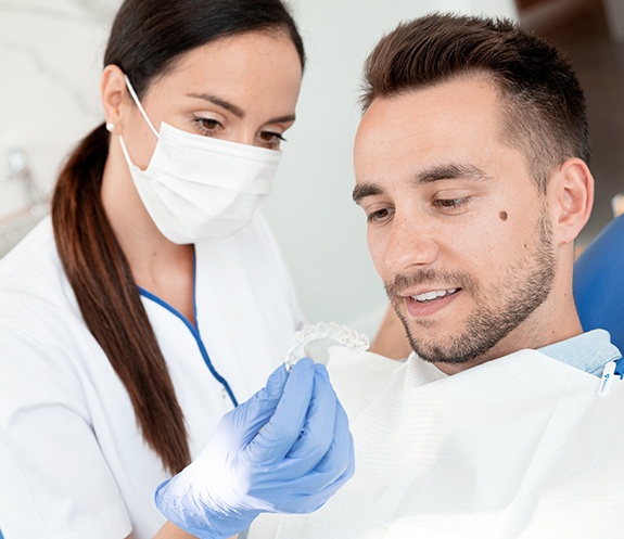 Dentist and patient looking at Invisalign tray