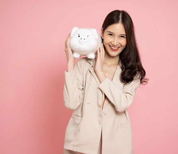 Woman holding a piggy bank on a pink background