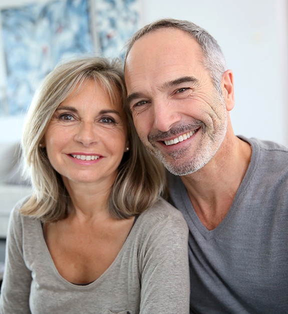 Man and woman sharing flawless smiles after makeovers