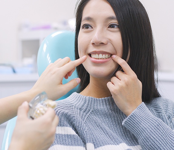 Woman pointing to smile after makeover