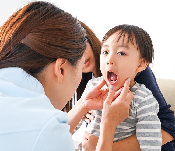 Dentist examing young patient during child's first visit