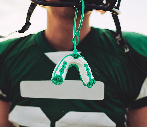 Teen athlete with athletic mouthguard attached to helmet