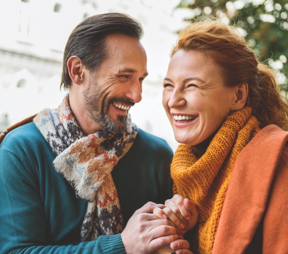 Man and woman smiling together and replacing missing teeth