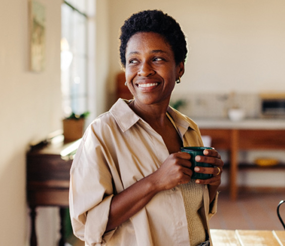 Smiling woman enjoying coffee at home