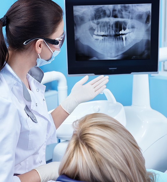 Dentist and patient looking at digital x-rays