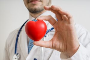 Doctor holding a small red heart