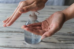 Patient using hand sanitizer at dentist in Friendship Heights