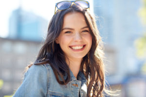 happy smiling young woman on summer city street