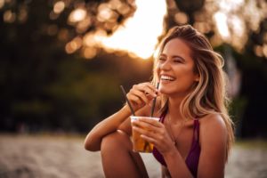 woman drinking beverage through a straw 