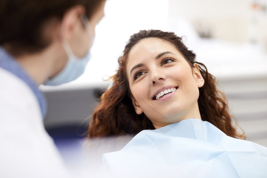 Woman smiling at dentist during checkup