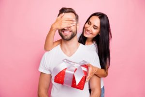 a woman giving her partner a smile-friendly Valentine's Day gift